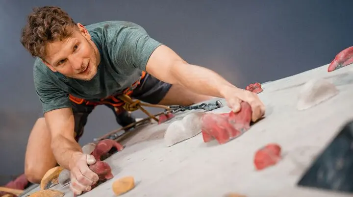 Ein Mann klettert an einer Boulderwand | © DAV