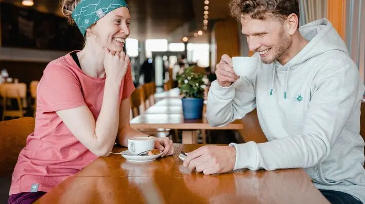 Zwei Menschen sitzen im Bistro eines Kletterzentrums | © DAV / Marisa Koch