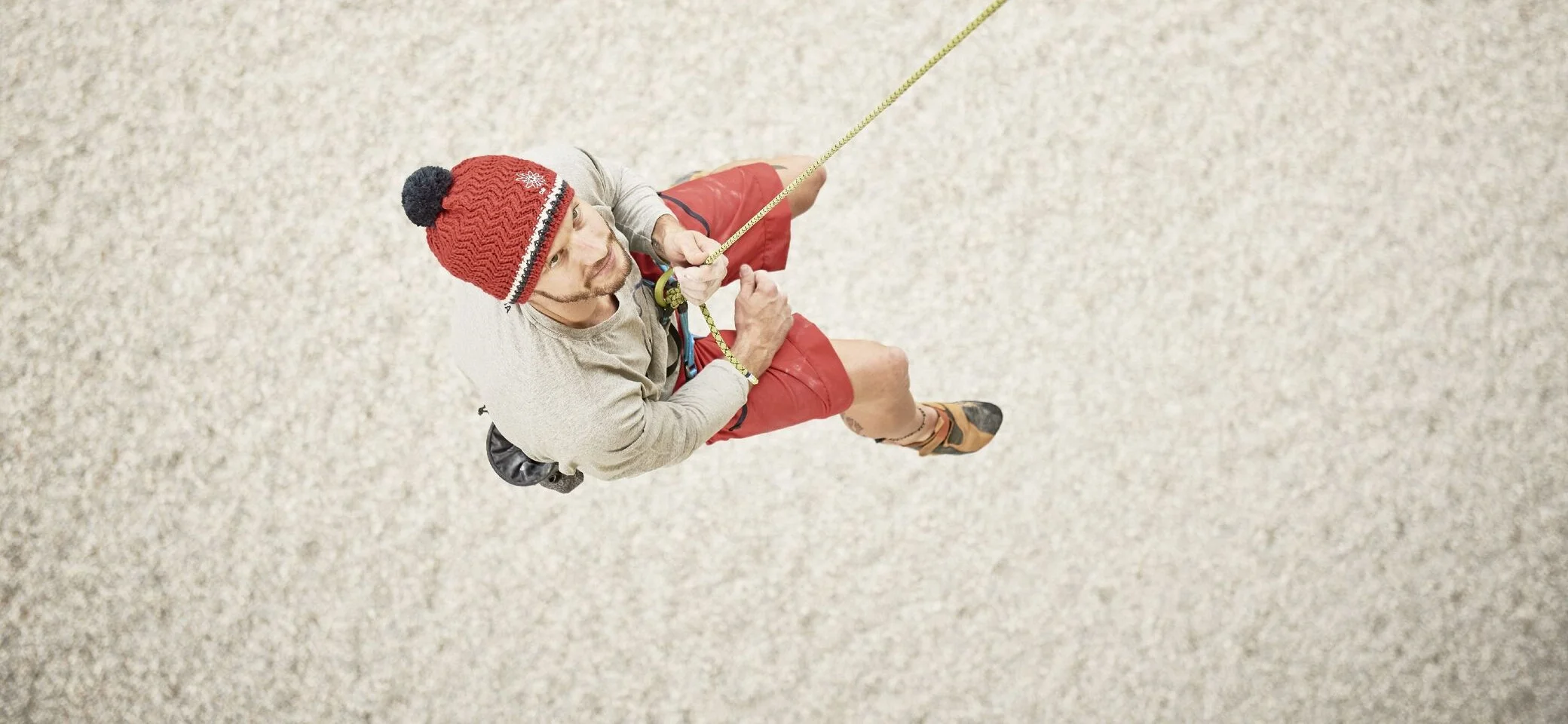 Eine Frau seilt seilt sich an einer Kletterwand ab | © DAV / Marisa Koch